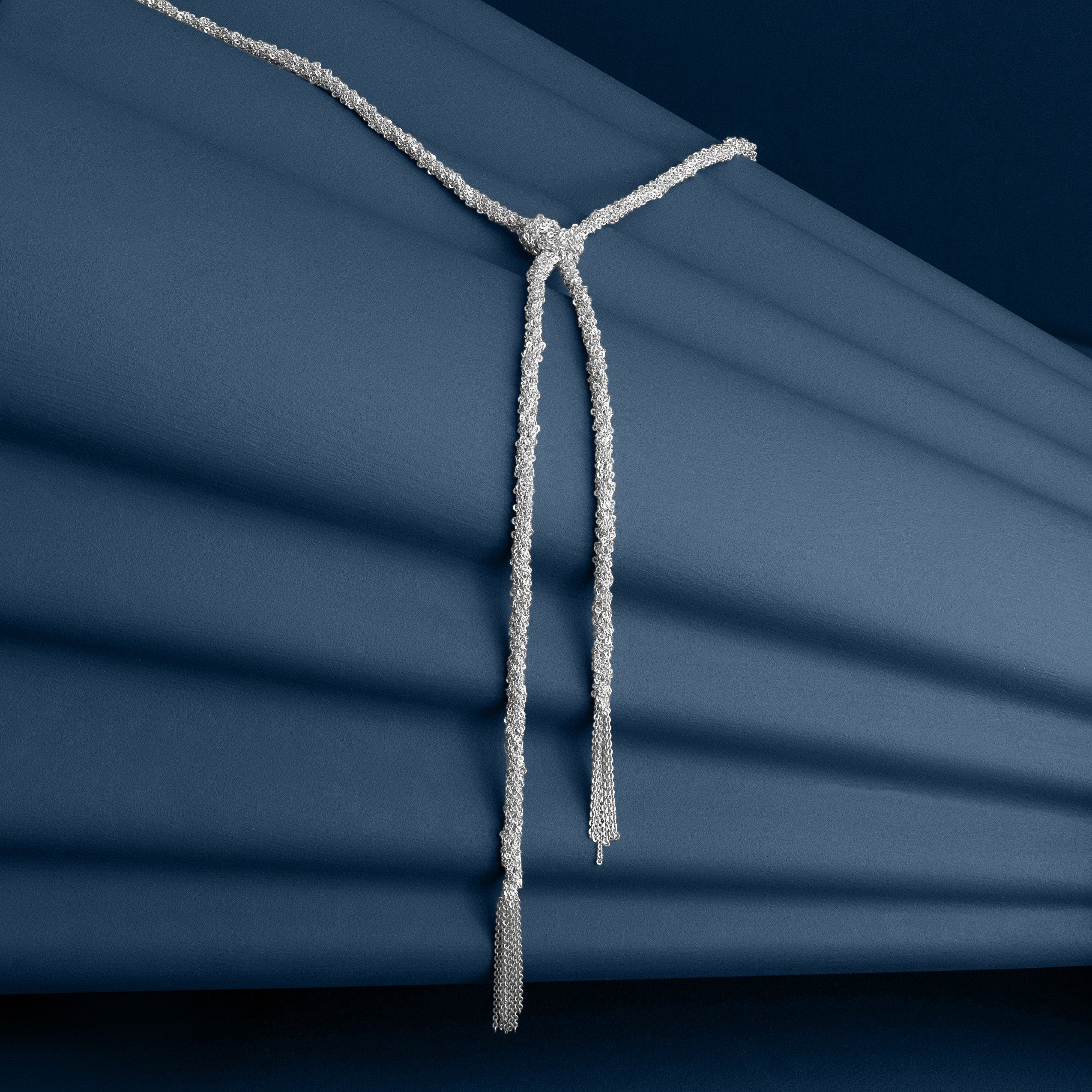 Loel Silver Thread Lariat Necklace on Blue background