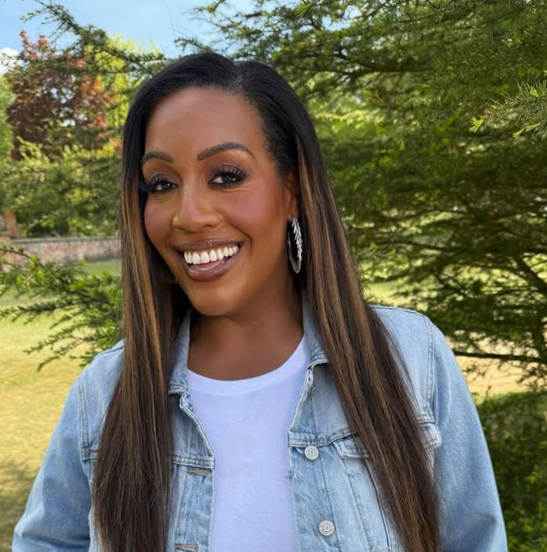 A smiling Amanda Hammond wearing LOEL Large Silver Tassel Hoop earrings outside