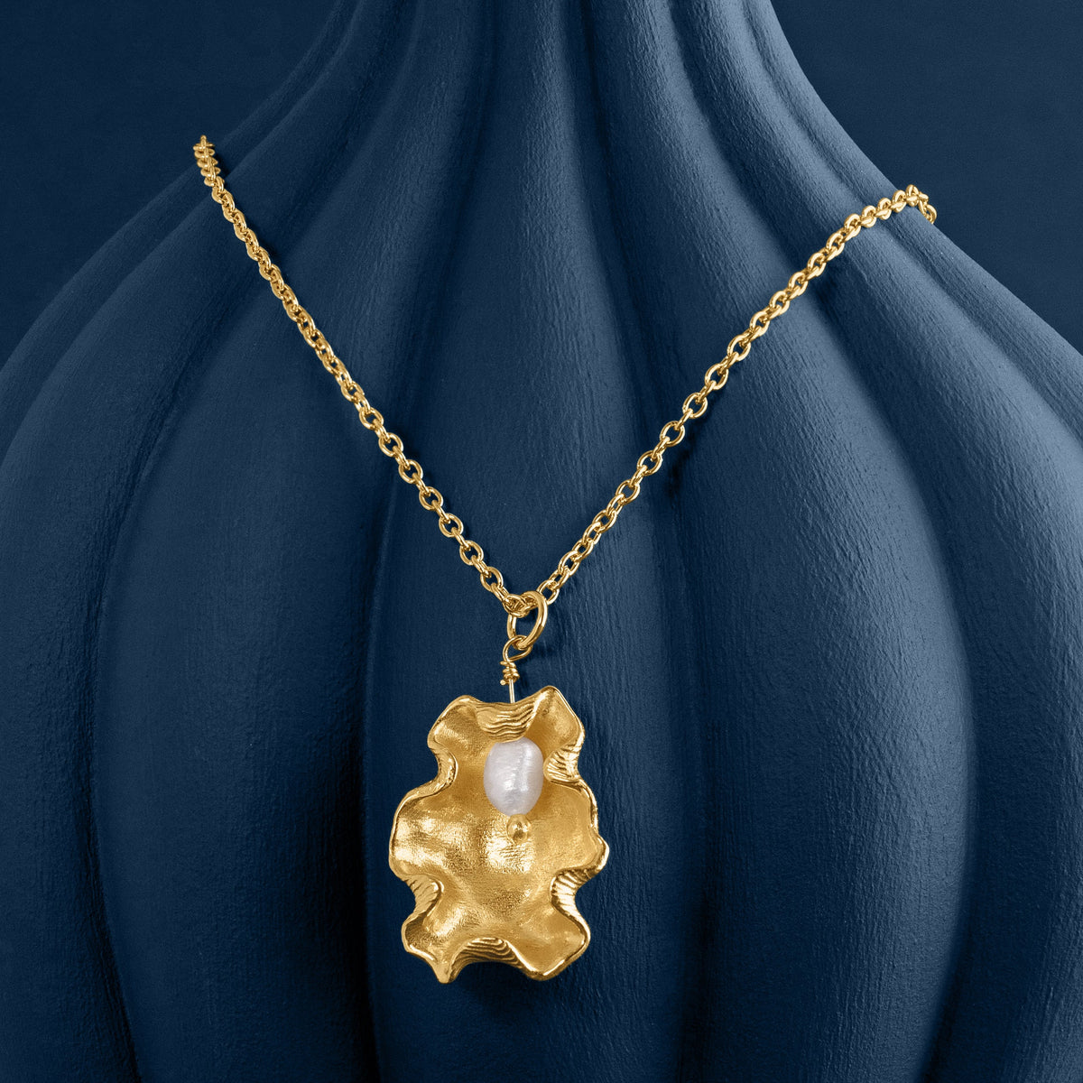LOEL x Minnie Mae Gold Oyster Shell and Pearl pendant v2 on blue vase
