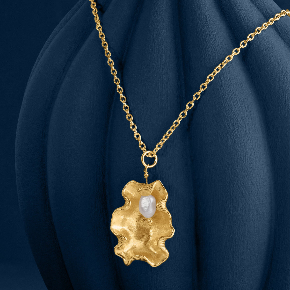 LOEL x Minnie Mae Gold Oyster Shell and Pearl pendant v2 on blue vase side