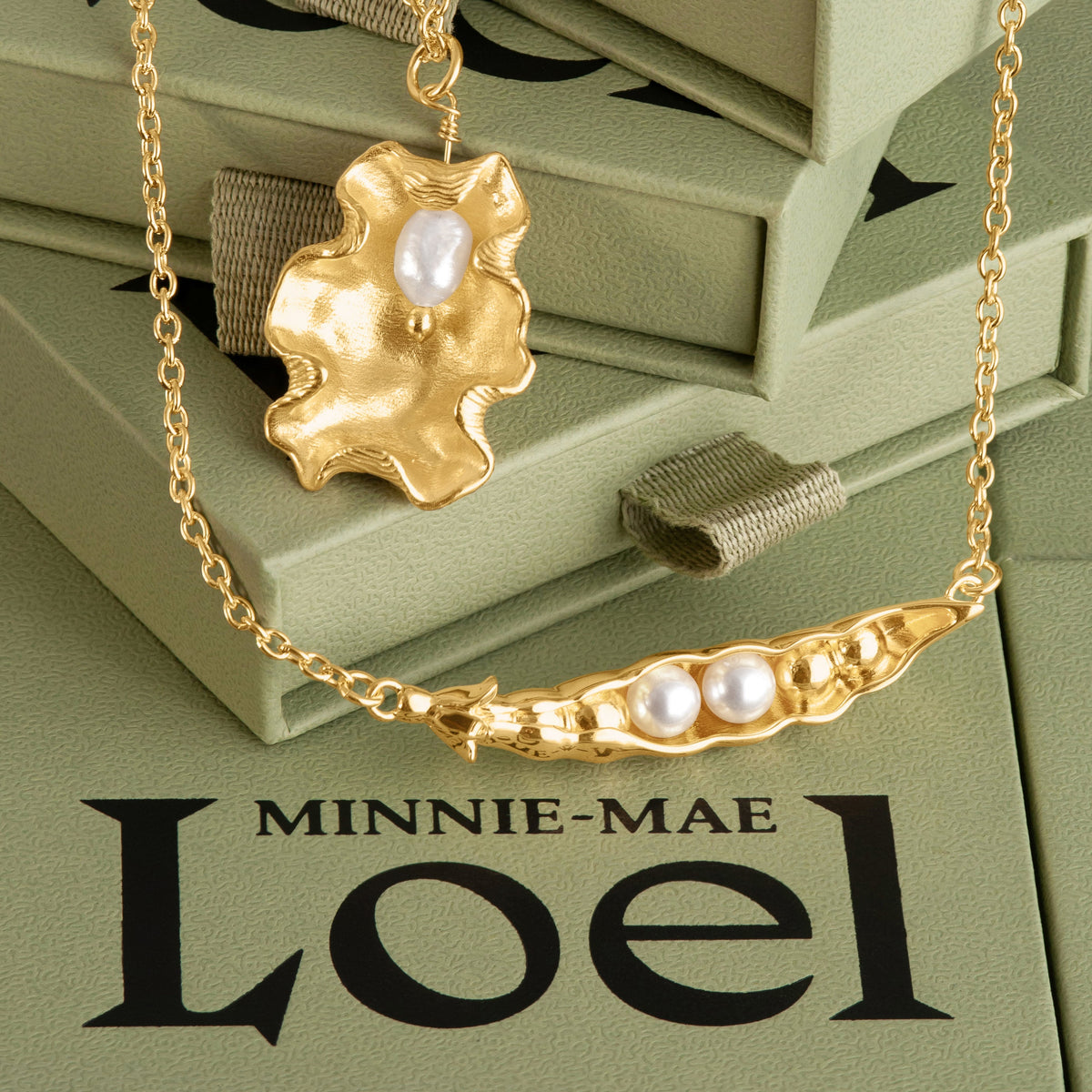LOEL x Minnie Mae Oyster Shell and Peas in a pod pendants on green boxes