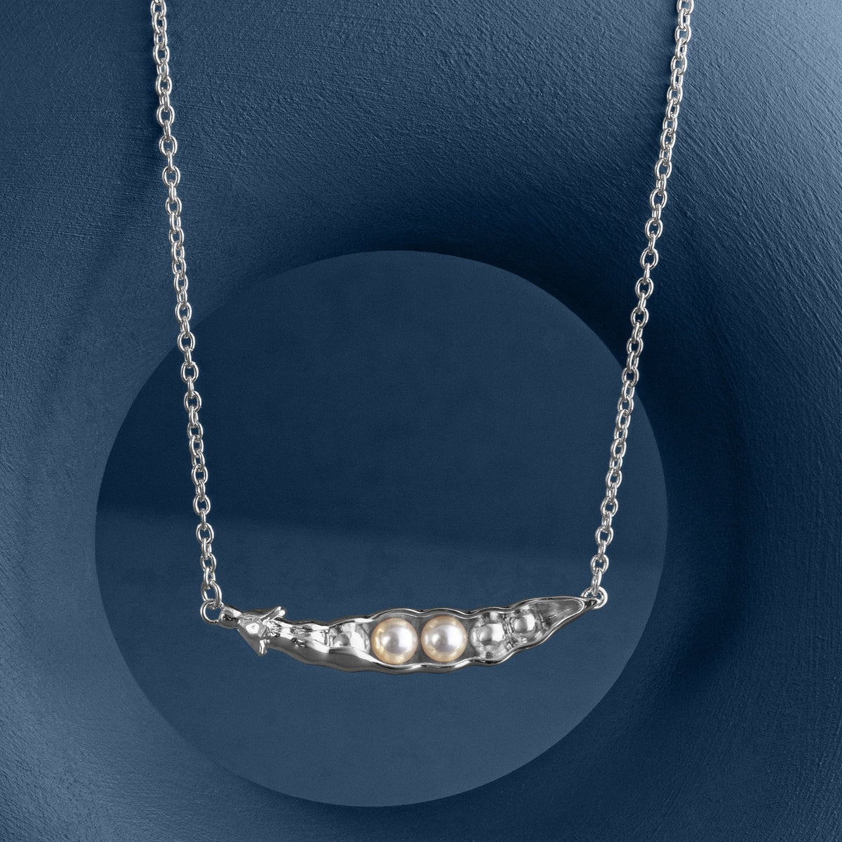 LOEL x Minnie Mae Silver Peas in a Pod Pendant hanging on blue