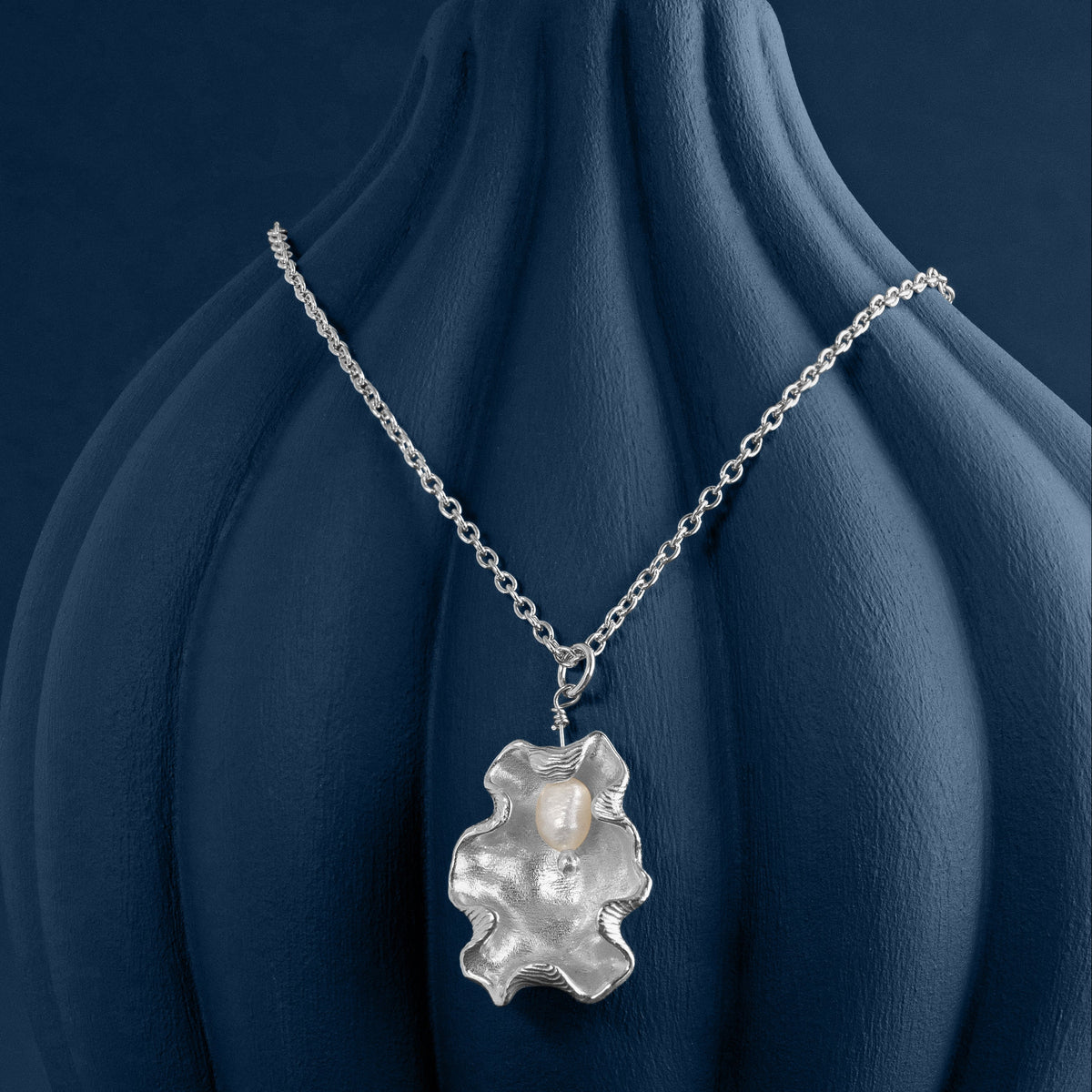 Loel x Minnie Mae Silver Oyster Shell Pendant on blue