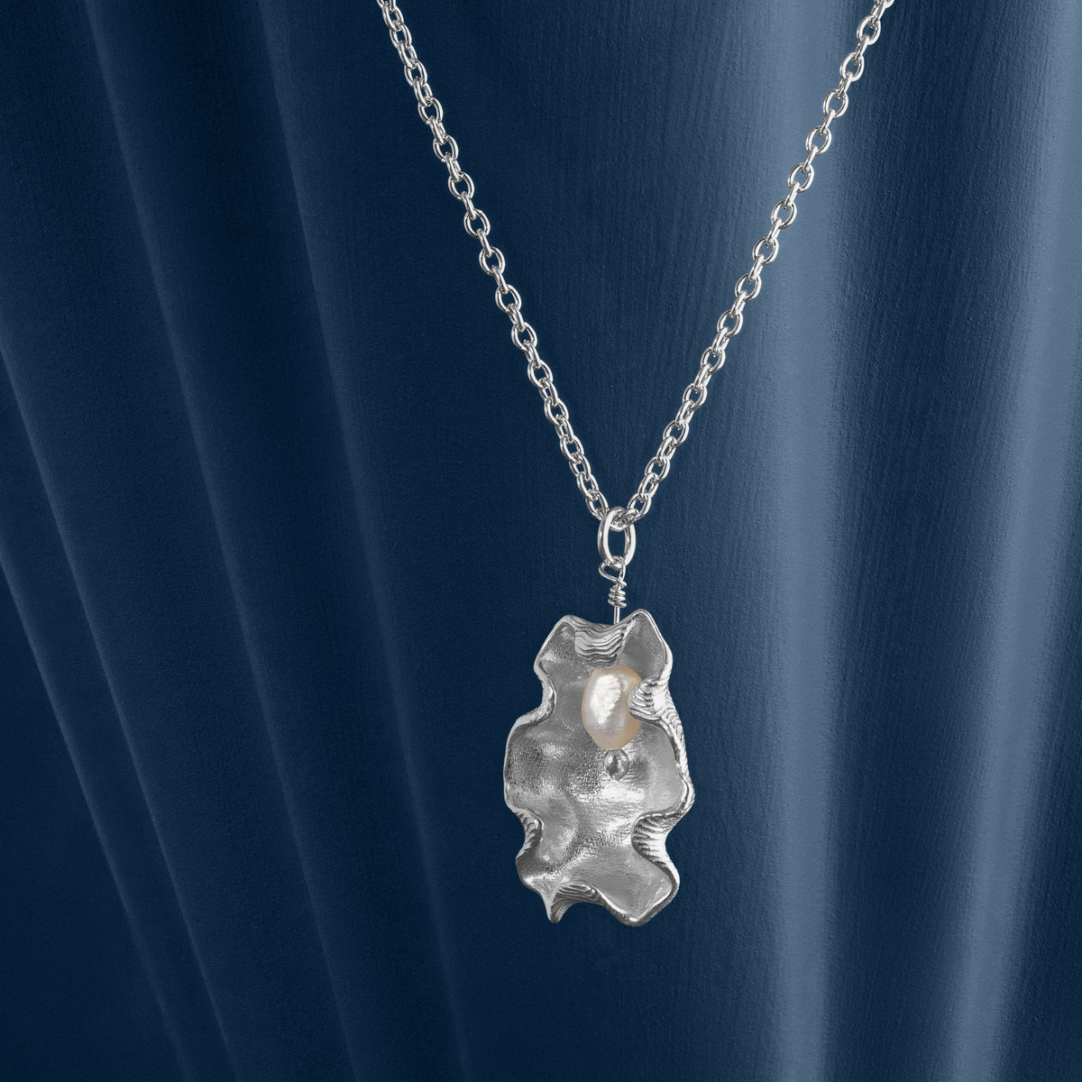 Loel x Minnie Mae Silver Oyster Shell Pendant on blue side